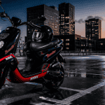 scooter booster 50cc noir rouge sur parking urbain