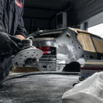 Outillage du carrossier : ponceuse pneumatique et cales en atelier de carrosserie